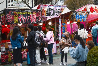 Japonya, Nisan 2024: Tokyo, Sensoji tapınağındaki Nakamise Dori 'de renkli gıda satıcıları standı