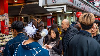 Tokyo, Japonya Nisan 2024 Kimliği belirsiz yabancı turistler yukata (kimono) giyiyorlar Japonya 'nın Tokyo, Japonya' daki ünlü tapınağı Sensoji 'de yürüyen ulusal gelenek. 