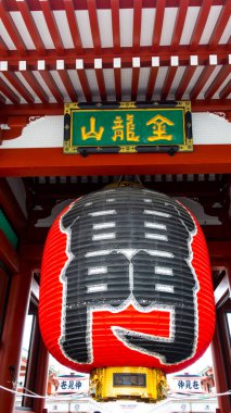 TOKYO, JAPONYAN - Nisan 2024: Senso-ji tapınağındaki Kaminari-mon 'da büyük bir Japon kırmızı feneri. Kırmızı büyük fenerdeki karakterler rüzgar tanrısının ve gök gürültüsünün kapısıdır..