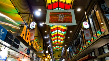 JAPAN, KYOTO Nisan 2024: Nishiki Pazarı 'nın canlı renkleri, taze ürünler ve yerel lezzetler, hediyelik eşyalar, Japon minimalist tarzı satan geleneksel tezgahlar.