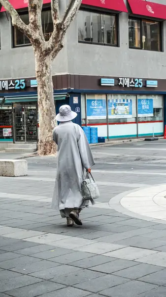 Seoul, South Korea, woman with a large white hat walking through the modern side of Myeong-dong area,  Seoul, South Korea