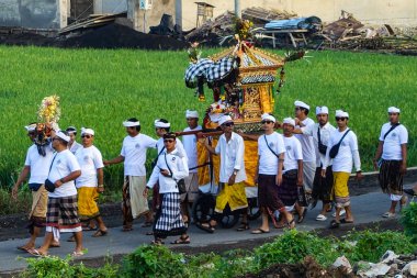 Kafalarında tapınak, adak ya da geboganlar taşıyan geleneksel giyinmiş kadın ve erkeklerin geçit töreni, Barong şeytanları, Endonezya 'nın Bali adasındaki Seseh sahilinde, Ağustos 2025' te sergilenecek.