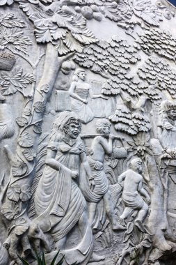 Endonezya, Bali, Endonezya, Ağustos 2025 'te Canggu caddesinde iki şeytanı temsil eden sınır duvarında güzel beyaz bir sıva desenli.