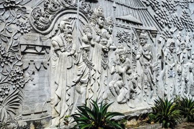 Hudut duvarında güzel beyaz sıva desenli insanlar Canggu, Bali, Endonezya 'da Ağustos 2025' te bir kral ve kraliçenin önünde saygıyla eğiliyor.