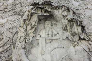 Güzel beyaz sıva desenli sınır duvarı Canggu, Bali, Endonezya 'da Ağustos 2025' te oturan kutsal Hindu bir adamı temsil ediyor.