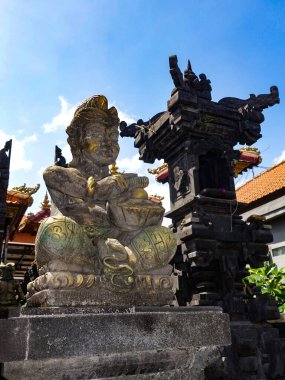 Bali 'de özel tapınaklar için özel bir kategori olmamakla birlikte, adanın bazıları diğerlerinden daha küçük veya daha tenha olan birçok tapınağı vardır. Bacaklarının arasında yılan olan Endonezya Tanrısı 'nın güzel oyulmuş heykeli. Bali, Endonezya, Aug