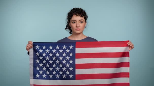 Poważna Młoda Kręcona Kobieta Niebieskim Swetrze Trzymająca Amerykańską Flagę Wyglądająca — Wideo stockowe