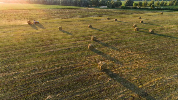 農業分野で農地の上にシラージュの俵を作るバリングマシンと空中ビュートラクター ドローンは干し草を収穫して農業用に干し草を撃ちました 農作物の伐採 収穫の季節 — ストック写真