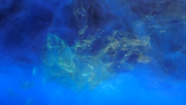 ゆっくり動く金の黄色いインクは青いインクと水で混合し 柔らかく水中で泳ぎます スローモーション 隔離されたペンキの着色されたアクリル雲 抽象的な煙の爆発アニメーション 美しいアートの背景 — ストック動画