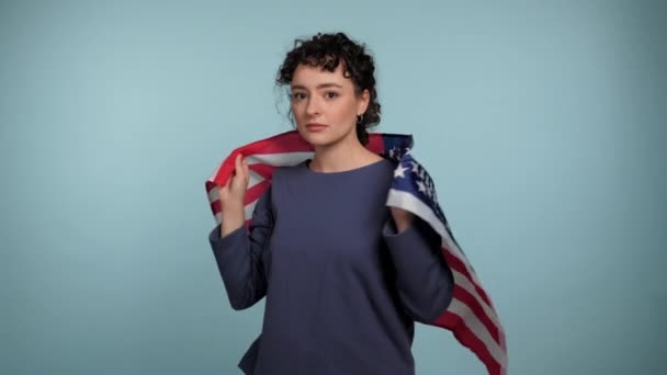 Serious Patriot Young Curly Woman Drapes Flag Shoulders Looks Camera — Stock Video
