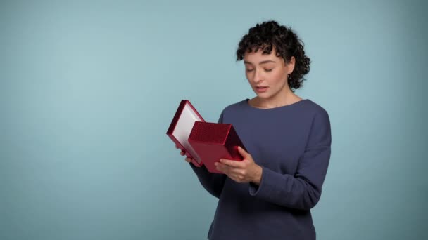 Shocked Curly Woman Opens Present Red Box Surprised Looks Camera — Stock Video