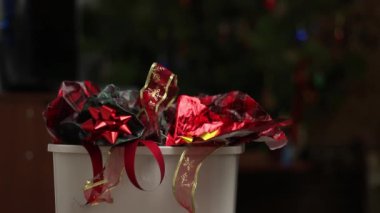Noel kâğıdı atıkları çöp kutusuna. Noel ağacı ışıkları, dekorasyonlar, tatil kartları, kullanılmış folyo, şenlikli plastik ambalajlar, kurdeleler. Yüksek kaliteli FullHD görüntüler