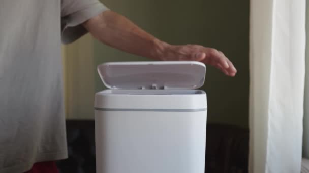 Een Man Gooit Een Lege Plastic Shampoo Container Een Vuilnisbak — Stockvideo