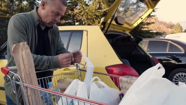 Voedselcrisis Voedselprijzen Stijgen Een Bezorgde Man Controleert Een Papieren Bonnetje — Stockvideo