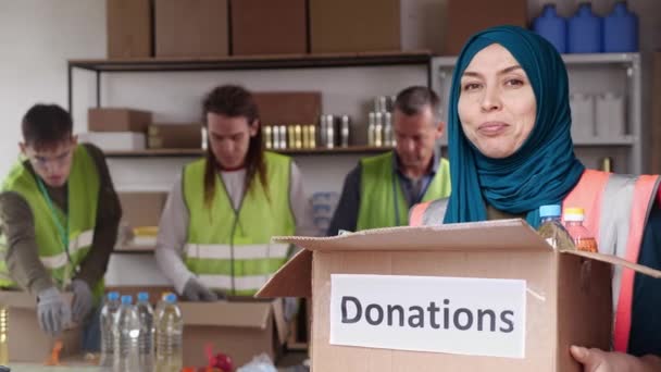 Muslimská Dobrovolnice Hidžábu Drží Dárcovskou Krabici Usmívá Vysoce Kvalitní Záběry — Stock video