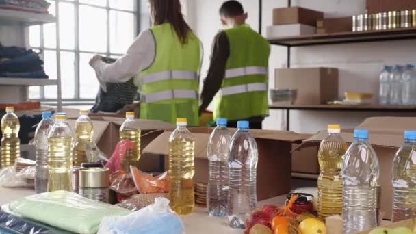 Εθελοντές Που Εργάζονται Ρούχα Και Κέντρο Δωρεάς Τροφίμων Φιλανθρωπία Βοήθεια — Αρχείο Βίντεο