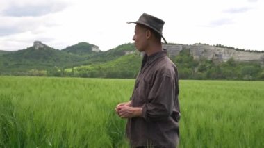 Buğday tarlasında üzgün bir çiftçi. Nitrojen gübre krizi, gıda krizi, iflas, çiftlik kapatma. Yüksek kalite 4k görüntü