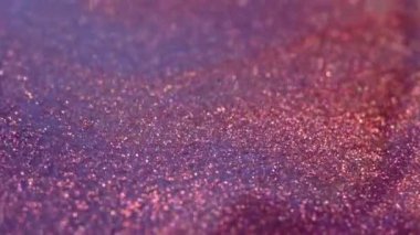 High Shimmering Pigments. Liquid with glitter macro . Pink purple metallic copper. Magical holographic glow and bokeh. Festive abstract background. High quality 4k footage