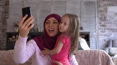 Müslüman anne ve kızı internet üzerinden iletişim kuruyor, bayram için tebrik ediyor ya da ortak selfie çekiyorlar. Yüksek kalite 4k görüntü