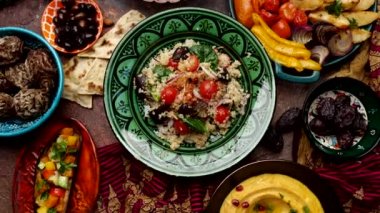 Quinoa with vegetables. Authentic oriental culinary composition in colorful dishes, served on a dark rustic background, top view. High quality 4k footage
