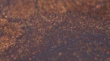 Metallic ink macro. Glitter shiny background. Motion mixed copper ink. Real hypnotic macro movement. High quality 4k footage