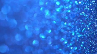 Mavi Işıldayan Arkaplan. Sihirli toz, parlak doku, tatil ışıkları, uçan parçacıklar güzel bir bokeh oluşturur. Parlak Noel arkaplanı. Dikey video. Yüksek kalite 4k görüntü