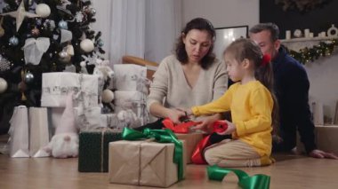 Noel bağışları. Çocuklar için oyuncaklar. Aile annesi, baba ve çocukları ihtiyacı olan çocuklar için Noel hediyeleri hazırlıyorlar. Yüksek kalite 4k görüntü