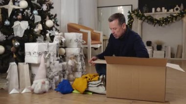 Baba ve kızı, Noel tatilinde bağışlanmak üzere kullanılmış giysiler ve oyuncaklarla dolu bir kutu topluyor. Yüksek kalite 4k görüntü