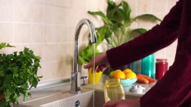 Yeniden kullanılabilir su şişesi. Plastiksiz. Sıfır Atık Yaşam Tarzı. Adam musluktan su döker. Yüksek kalite 4k görüntü