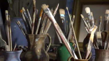 Sanat stüdyosu ya da sanatçı sınıfı, yaratıcılık atölyesi. Profesyonel boya aletleri, fırçalar, yağlı boya, palet, tuval, sehpa, resim çerçeveleri, palet bıçağı. Yüksek kalite 4k görüntü