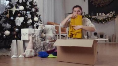 Baba ve kızı, Noel tatilinde bağışlanmak üzere kullanılmış giysiler ve oyuncaklarla dolu bir kutu topluyor. Yüksek kalite 4k görüntü