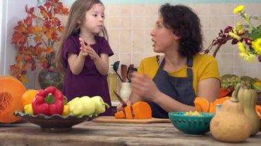 Şükran Günü yemeği için birlikte yemek pişiriyoruz. Dişi çiftçi anne ve küçük kız hasat festivali için balkabağı turtası pişiriyorlar. Yüksek kalite 4k görüntü