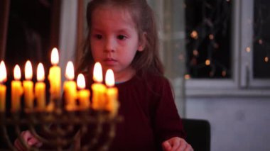 Hanuka. Bir Menorah ve Yahudi Tatili Aydınlatma. Menorah Mumları 'na bakan çocuk. Yüksek kalite 4k görüntü