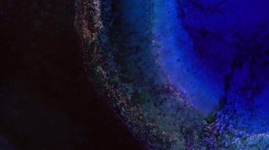 Koyu mavi mor renkler mürekkep ve parlak parçacıklar makro. Sıvı soyutlamalar. Renkli, şaşırtıcı, lüks bir geçmişi var. Akışkan sanat. Evren, evren. Yüksek kalite 4k görüntü