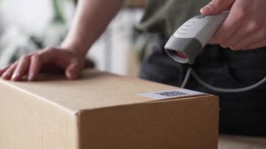 Depo çalışanı bir QR kod okuyucusu kullanıyor, sistemdeki paketleri tarıyor, mal paketlerini kontrol ediyor ve mal envanterini çıkartıyor. Yüksek kalite 4k görüntü