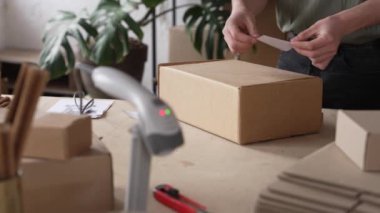 Küçük işletme sahibi paketi bir QR kodu ile işaretler, paketleme ve siparişi müşteriye gönderir. Yüksek kalite 4k görüntü
