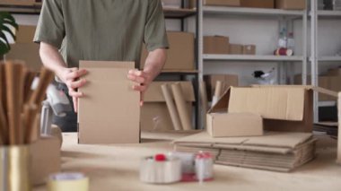 Genç Adam karton kutuda paketleme ürünü. Müşteriye teslimat için. Yüksek kalite 4k görüntü