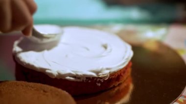 A Boy Smears A Biscuit Cake With Milk Cream. Family Weekend. Cake Cream. Culinary Preparation Of Sweets. Ingredients For Pie Baking For The Holiday.