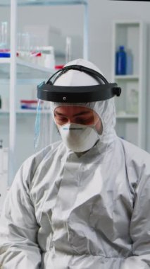 Dikey video: Bilimsel donanımlı laboratuvarda çalışan yorgun kimyager adam doktorunu kapatın. Çeşitli bakteri, doku ve kan örnekleri, ilaç araştırmaları üzerinde çalışan bilim adamları