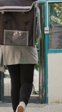 Dikey video: Pervasız fast food çalışanı pizza kutularını düşürüyor, müşteriden kaçan kadın taşıyıcıdan korkuyor. Beceriksiz kurye pizzacı siparişi, kötü teslimat servisi. Üçayak atışı.