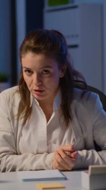 Dikey video: Pov of business woman is yerindeki kameraya gece yarısı bir video konferansı düzenliyor. Modern teknoloji ağını kullanan bir bayan sanal toplantı için...