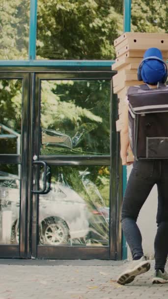 垂直视频 披萨店的女快递员把披萨盒堆在顾客的前门 笨手笨脚地跑着 送货服务差 外卖餐厅员工试图接住掉下的包裹 — 图库视频影像