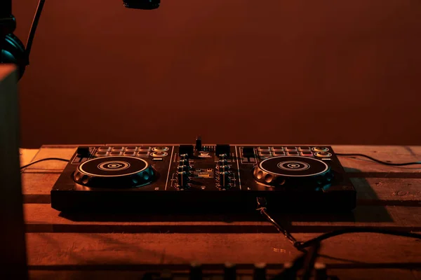 Empty table with stereo turntables and dj equipment, audio instrument with microphone and headphones. Electric vinyl used at nightclub or party to mix and listen to techno music, electronics.