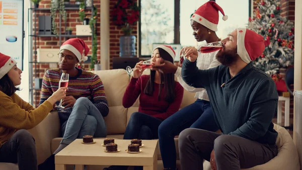 オフィスパーティーイベントでクリスマス休暇を祝う 歓声を言うためにアルコールでグラスをクリックする多様な人々 クリスマスを祝うためにワインドリンクとトーストを行うお祭りの同僚 Eveシーズン — ストック写真