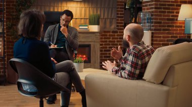 Psikanaliz terapisti, ilişki sorunları olan evli insanlara danışmanlık yapıyor, çatışmaları dinliyor ve tavsiyelerde bulunuyor. Psikolog psikoterapi seansında karı ve kocayla konuşuyor..