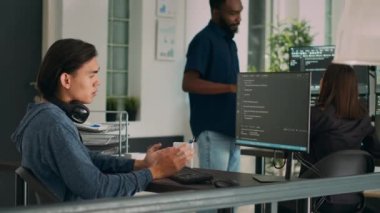 Bilgisayar ekranına ve daktiloya bakarak, terminal penceresinde html betiği ile çalışan sistem mühendisi. Ofisteki yazılım geliştiricisi ai algoritması ve sistem programlamasını yeniliyordu.