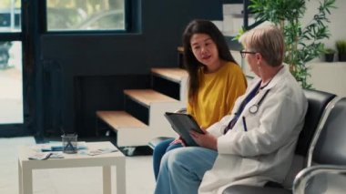 Dijital tablet ve kağıtlardaki sağlık raporlarını analiz eden, sağlık merkezindeki muayeneye katılmadan önce tıbbi form dolduran çeşitli yaşlı kadınlar. Teşhis ve tedaviden bahsediyorum..
