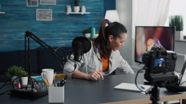 Ünlü internet içeriği yaratıcısı halka seslenirken alışveriş torbalarını açıyor. Popüler sosyal medya etkileyicisi moda öğelerini gözden geçirip izleyicilere sunarken.