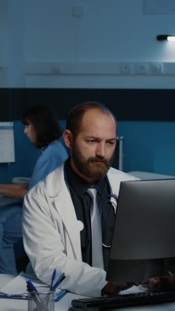 코트를 전문의 가카메라 앞에서 웃으면서 환자의 전문적 서비스를 컴퓨터로 작성하는 — 비디오