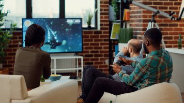 Mutlu insanlar video oyunları oynar ve yarışmayı kazanır, TV konsolunda online yarışmayı kazanır. Ev partisinde başarıyı çekerken eğleniyor ve neşeli hissediyorum..